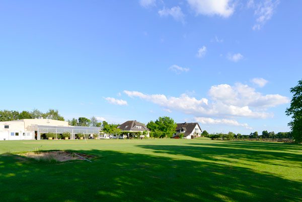 Golfplatz in Karben mit Golfbällen auf dem Rasen und Häuser im Hintergrund